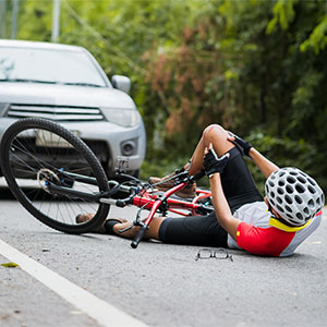 An injured man is on the ground after a bicycle accident - Pigott Law Group