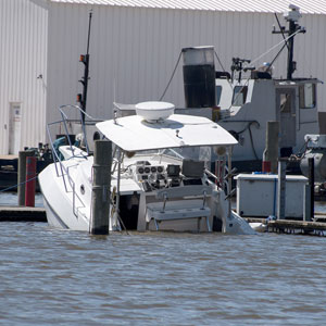 Boat partially underwater near dock, emphasizing the dangers of boating accidents. - Pigott Law Group